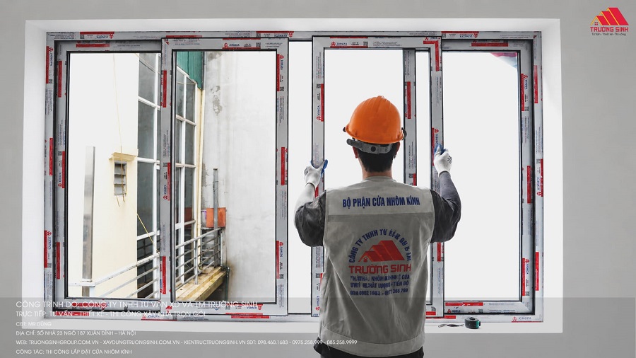Thợ đang lắp đặt cửa sổ nhôm kính
